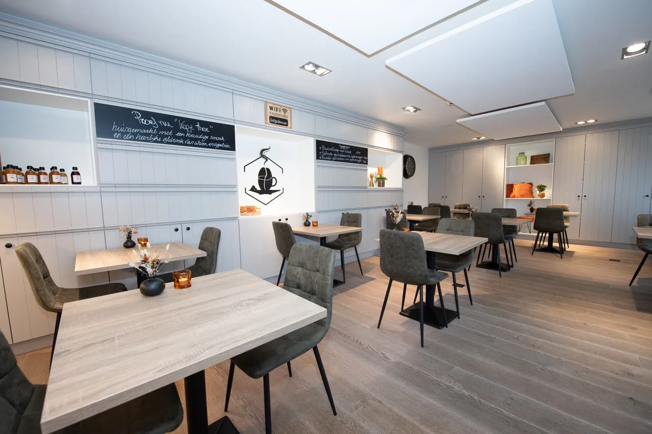 De zaal met de tafels langs het krijtbord